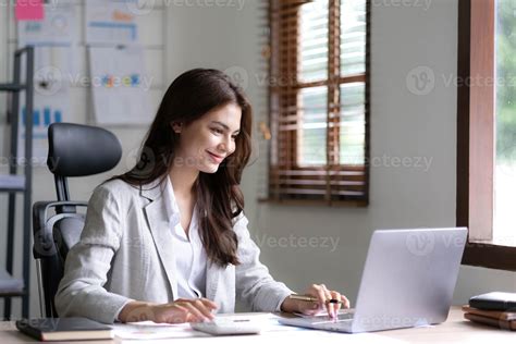 Woman working on a laptop with a clean white document