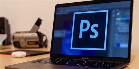 A person using a laptop with the Photoshop online interface displayed on the screen