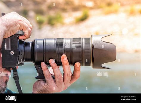 Photographer holding a camera steady with a tripod
