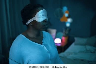 Person wearing a sleep mask in a dimly lit room