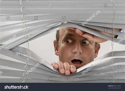 A person looking at a garden through a window with reflections
