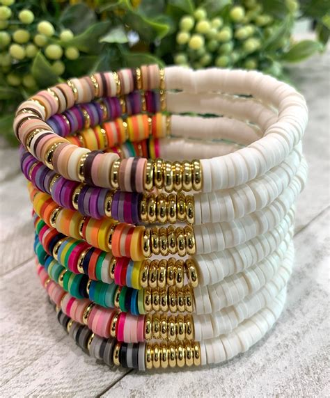 Stack of colorful beaded bracelets and simple gold rings