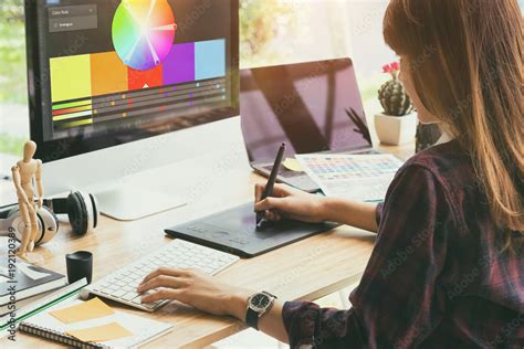 Graphic designer working on a computer with Adobe InDesign open