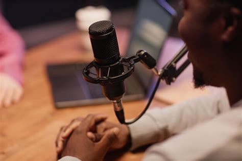 A person speaking into a professional microphone in a sound-treated studio.