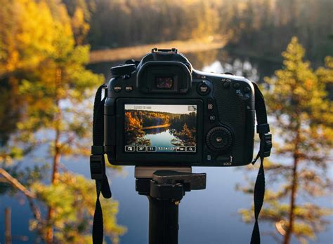 Photographer looking through camera viewfinder at a landscape