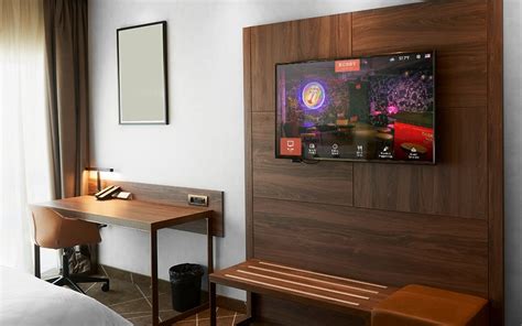 A clean and simply furnished hotel room with a TV and a fan