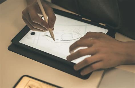 A person drawing on a tablet outdoors