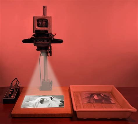 Photographer using a darkroom enlarger