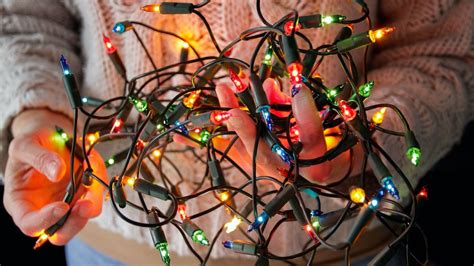 office workers tangled in christmas lights
