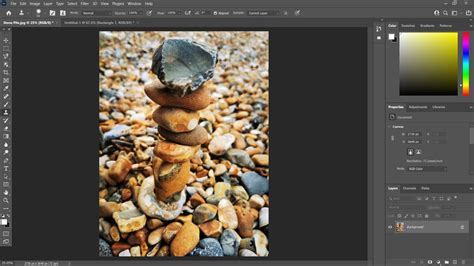 Photoshop interface showing the Clone Stamp Tool in action, sampling from one area of a pebble background and painting into an extended area
