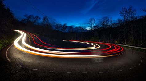 A photograph illustrating motion blur with car light trails at night.