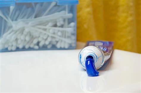 tube of white toothpaste and a cotton swab